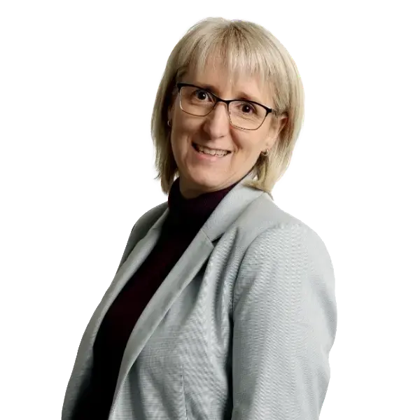 Isabelle Mercier Conseillère hébergement Visavie Comfortable senior caregiver smiling in a light gray blazer and black turtleneck, promoting elderly care services.