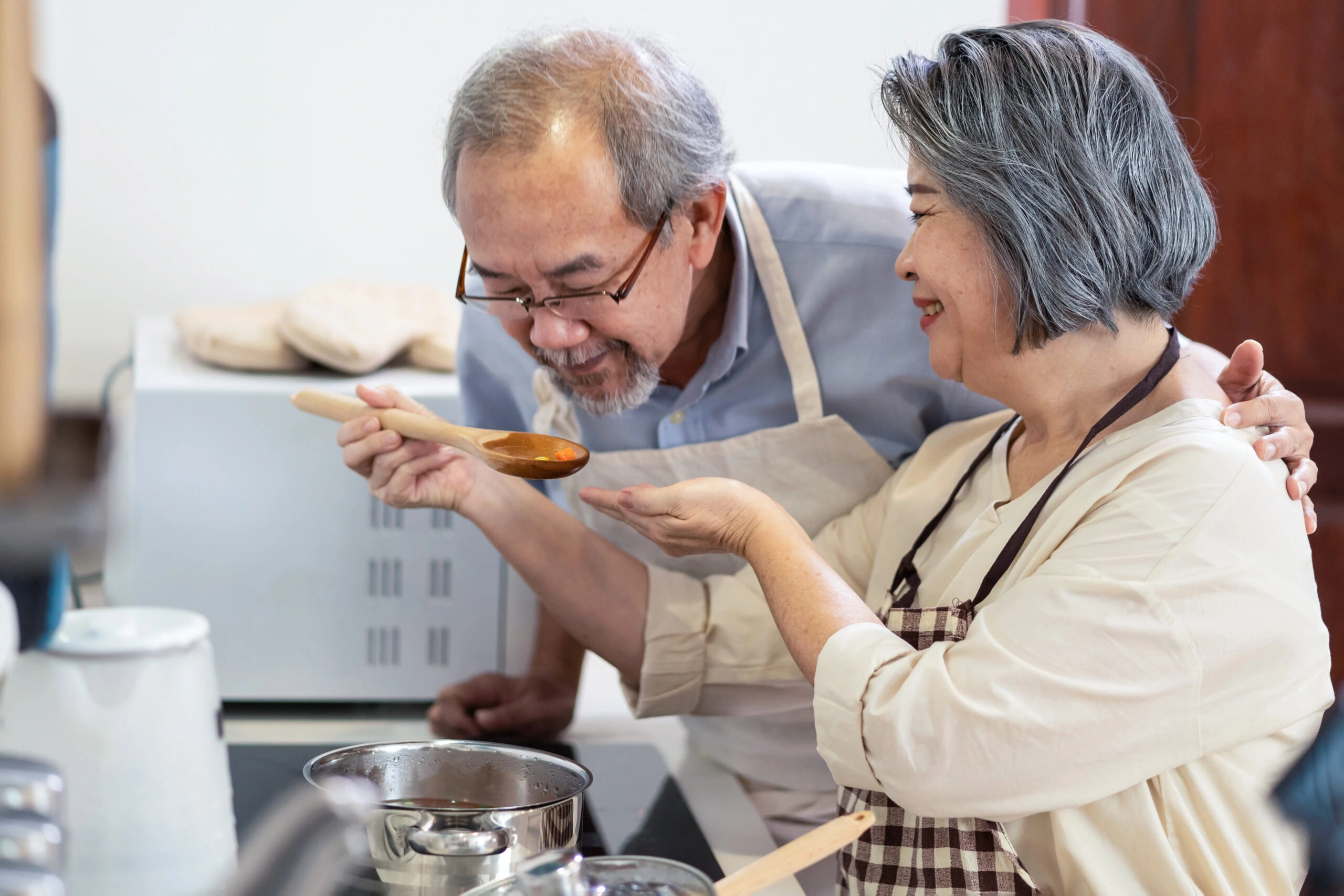 Mode de vie autonome Warm elder care with engaging cooking activities in a supportive environment.