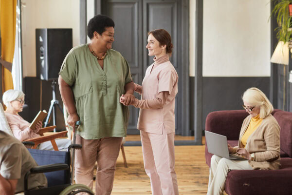 Compassionate senior care with friendly staff helping elderly residents in supportive environment.